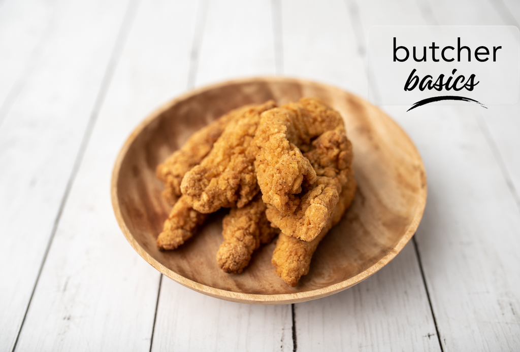 Frozen, breaded chicken fingers in a handcrafted wooden serving dish