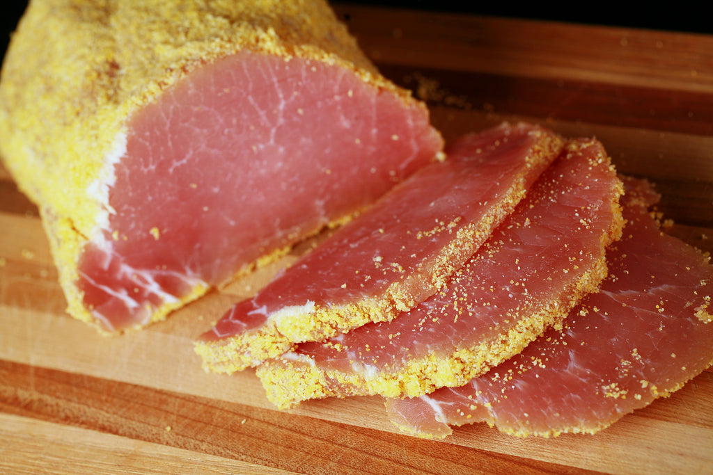 Sliced peameal bacon on a wooden cutting board