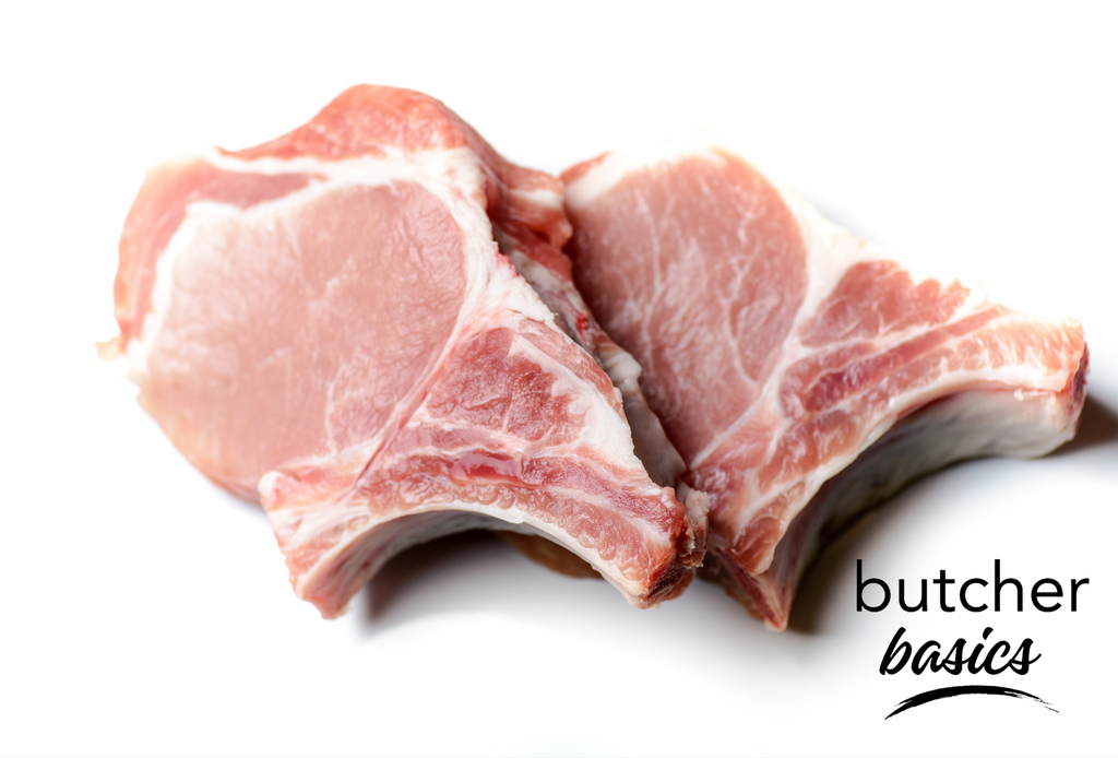 Two fresh, bone-in center-cut Ontario pork chops on a white background