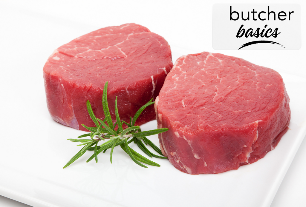 two fresh beef tenderloins with a sprig of rosemary on a white background