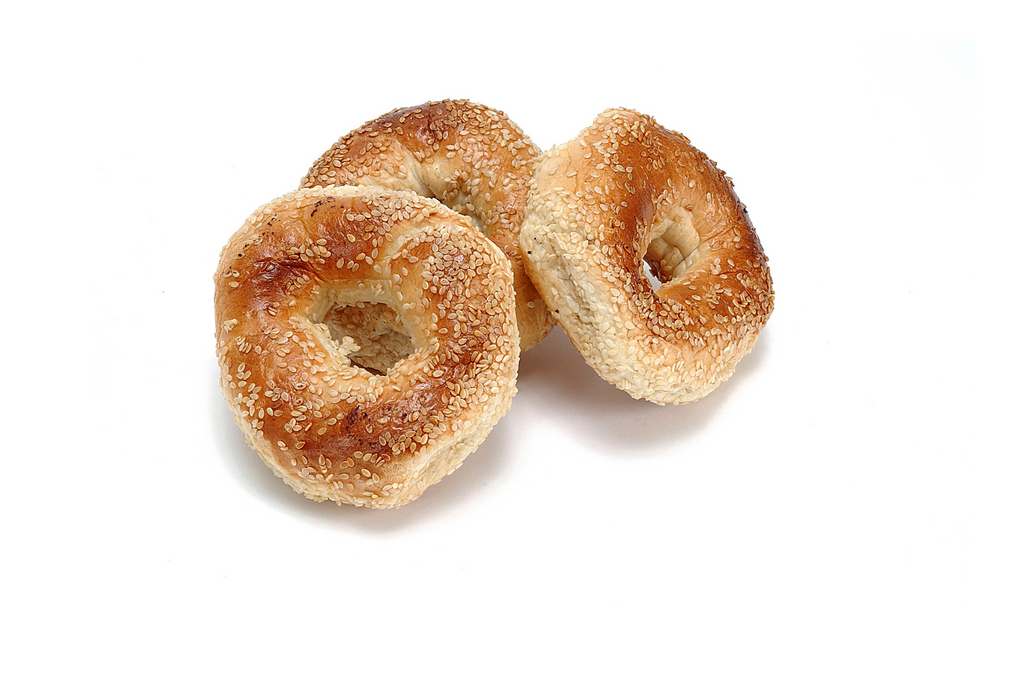 Three everything bagels against a white background