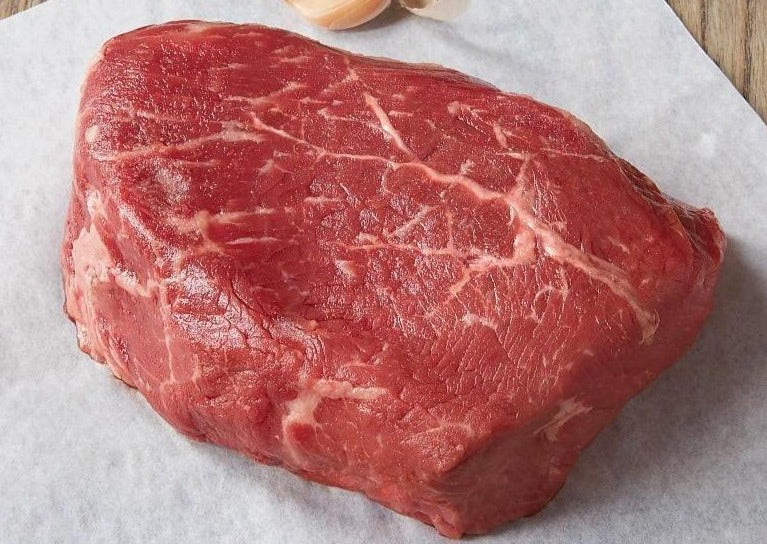 A fresh, bbq-ready baseball steak on white parchment paper