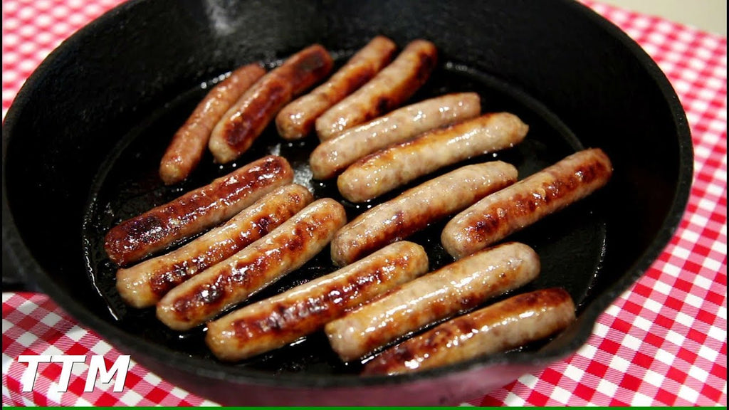 breakfast sausages in a cast iron skillet resting on a red and white tablecloth