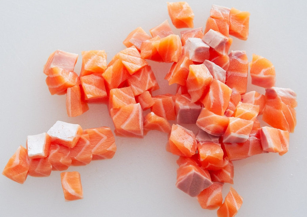 Cubes of poke salmon against a light grey background