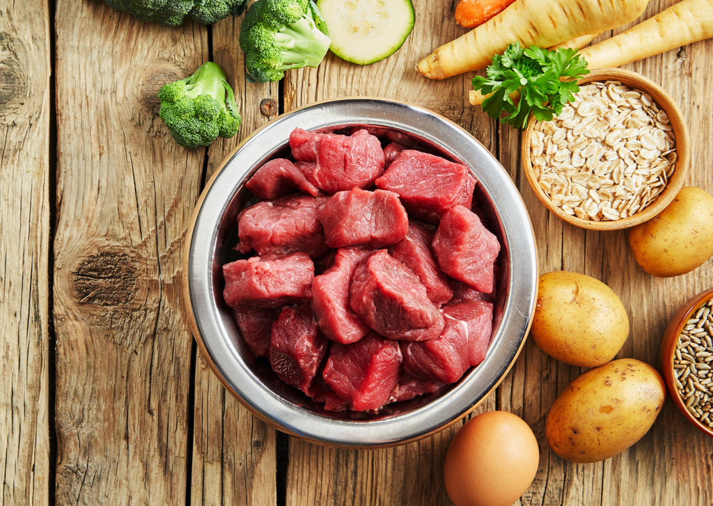 Bowl of cubed beef tenderloin tips with potatoes, vegetables and spices on a wooden tabletop